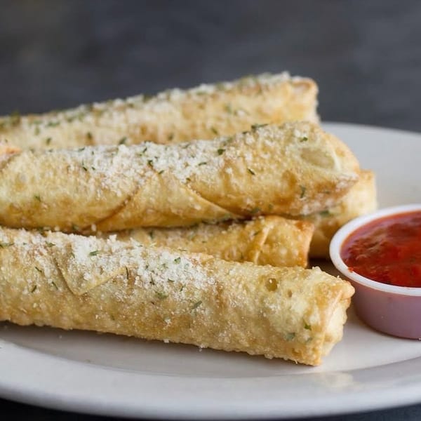 Golden-brown mozzarella sticks, sprinkled with parmesan and herbs, served with a side of marinara sauce.